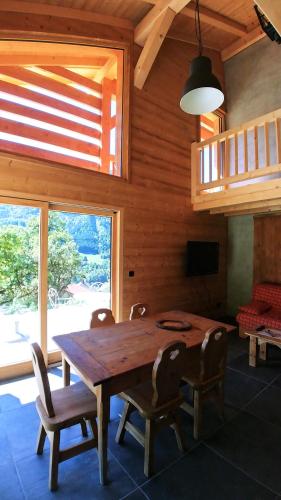 une salle à manger avec une table et des chaises en bois dans l'établissement Demi-Chalet Savoyard, à Le Petit-Bornand-lès-Glières