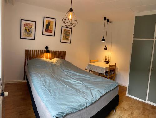 a bedroom with a large bed and a table at Fasanvej 3 Lille værelse in Middelfart