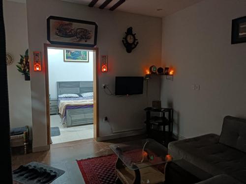 salon z kanapą i drzwiami do sypialni w obiekcie Islamabad Comfort Home w mieście Islamabad