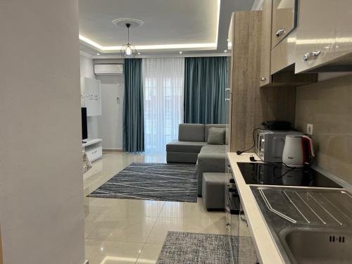 a kitchen and living room with a couch and a table at Fishta Apartment Q6 47 in Velipojë