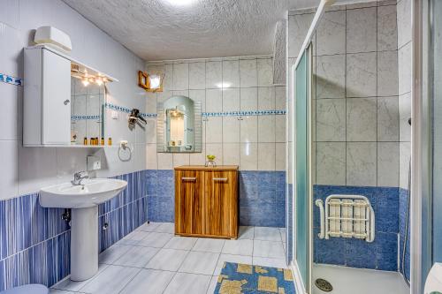 a blue and white bathroom with a sink and a shower at Apartments Cindrić in Selce