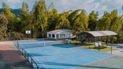 a tennis court with a net and a house at Finca Hotel Los Alpes in Manizales