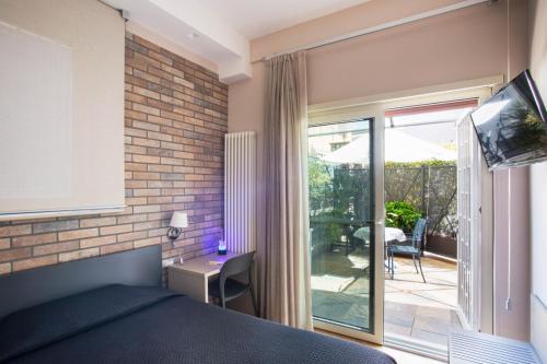 Schlafzimmer mit einem Bett und einem Balkon mit einem TV in der Unterkunft Little Rock Guest House in Gaeta