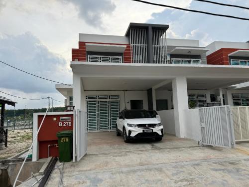 a car parked in front of a house at Acik Homestay in Pokok Sena
