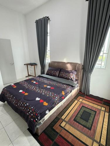 a bedroom with a large bed with a rug at Acik Homestay in Pokok Sena
