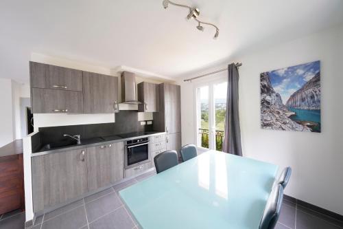 une cuisine avec une table et des chaises ainsi qu'une fenêtre dans l'établissement T2 40m2 Ollioules, la nature, à 10 mins des plages, à Ollioules