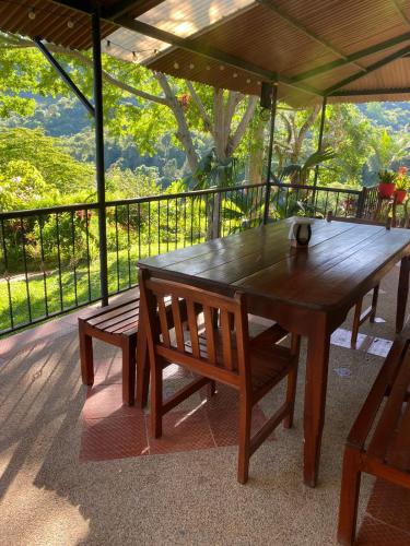 a wooden table and two benches on a deck at Finca San Jerónimo in Arbeláez