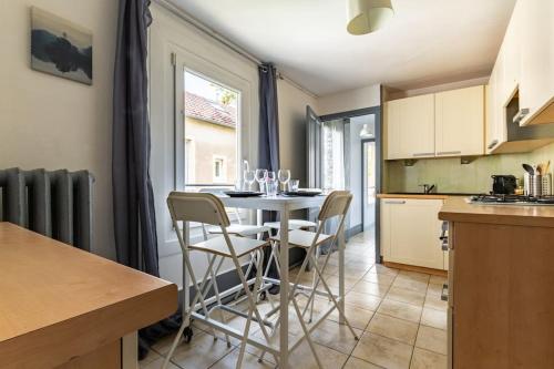 une cuisine et une salle à manger avec une table et des chaises dans l'établissement Le zen, à Dijon