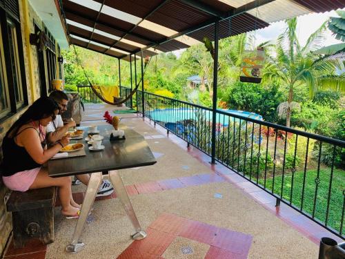 two people sitting at a table with food on a balcony at Finca San Jerónimo in Arbeláez