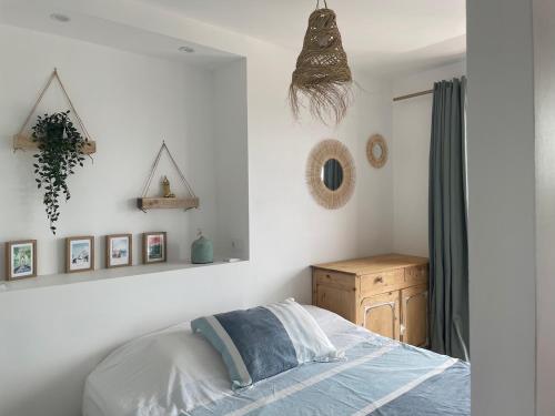 - une chambre avec un lit et des photos sur le mur dans l'établissement Les pins du Capri - Meublé de tourisme 3 étoiles, à La Grande Motte