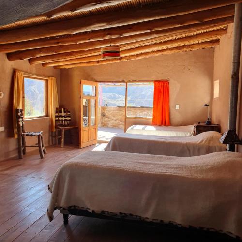 a bedroom with two beds and a large window at Casa La Molina in Tilcara