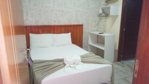 a bedroom with a bed with a bow on it at Pousada e Hostel Maria Bonita in Paripueira