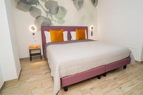 a bedroom with a large bed with orange pillows at Vesuvio Inn Bed & Wine Experience in Boscotrecase