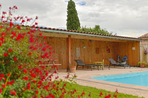 une piscine avec deux chaises et une table à côté d'un bâtiment en bois dans l'établissement La Ferme des Denis, à Chanos-Curson