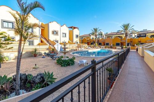 einen Balkon mit Pool, Palmen und Gebäuden in der Unterkunft Sea View Luxury Apartment - Playa del Duque in Adeje