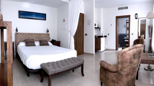 a bedroom with a bed and a pair of chairs at Atrium Hotel in Bolnuevo