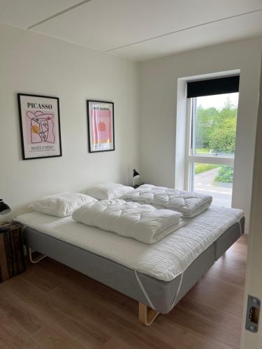 ein großes Bett in einem weißen Zimmer mit Fenster in der Unterkunft Casa House of bricks 3 - LEGO HOUSE 300 meters - Town center 200 meters in Billund