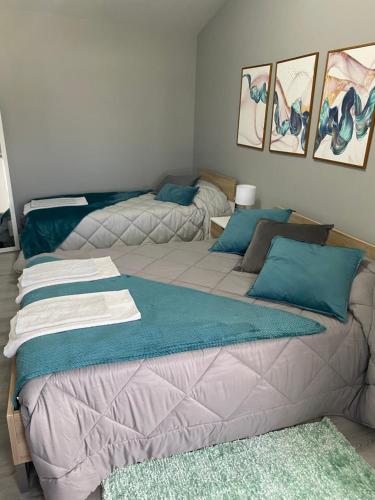 two beds in a room with blue pillows at Hortênsia's AL in Praia da Vitória