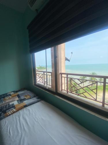 Schlafzimmer mit einem Fenster mit Meerblick in der Unterkunft PD Seaview Paradise Lagoon Apartment in Port Dickson