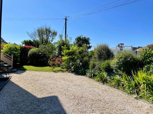 a garden with a bench and flowers and plants at PENTY Tregana in Porsmilin