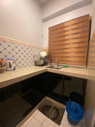 eine Küchentheke mit einem Waschbecken und einem Fenster in der Unterkunft PD Seaview Paradise Lagoon Apartment in Port Dickson