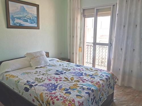 a bedroom with a bed with a quilt on it at Casa Corales in Castell de Ferro