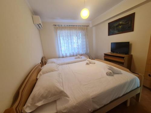 ein Schlafzimmer mit einem Bett und einem Fernseher darin in der Unterkunft Egi's Apartment in Shkodra