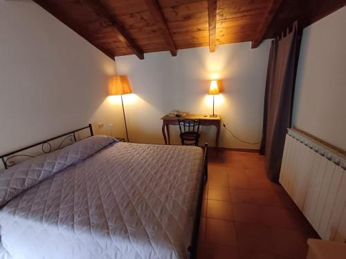 a bedroom with a bed and a table with two lamps at Casa Clotilde in Verbania