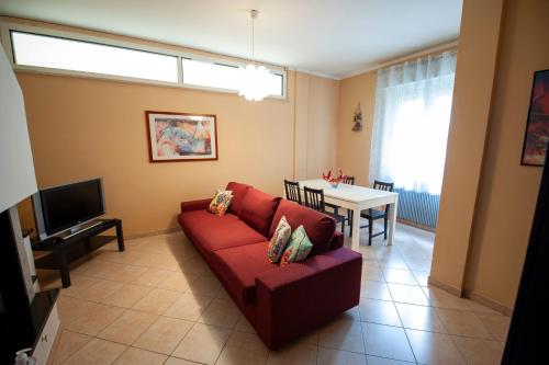 a living room with a red couch and a table at A casa di Debby alloggio comodo e accogliente in Foligno