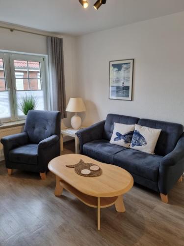 a living room with a couch and a coffee table at Hotel Garni Friesenhuus in Greetsiel