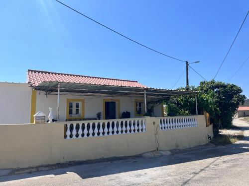a white house behind a white fence at Casa da avó Delmira in São Marcos da Serra
