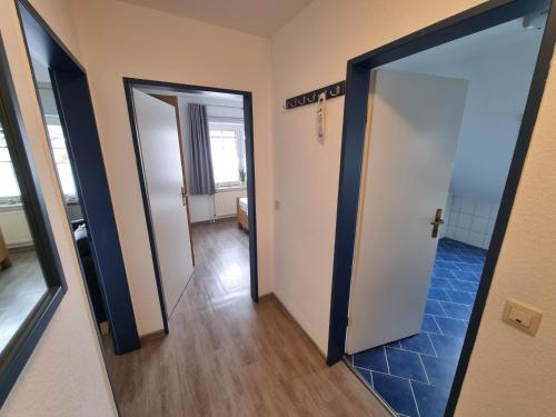 a hallway with two doors and a mirror at Hotel Garni Friesenhuus in Greetsiel
