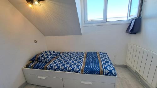 un lit dans une petite pièce avec une fenêtre dans l'établissement Studette éco près du phare, à Calais