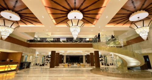 a lobby with three chandeliers in a building at Henann Resort Alona Beach in Panglao