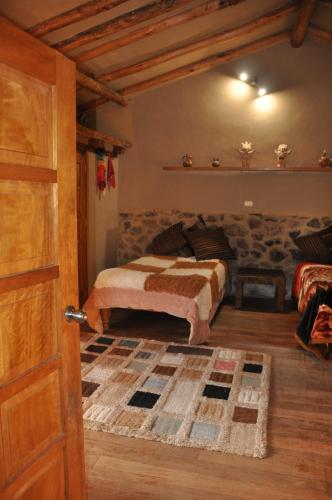 Valle Dorado Lodge في كوسكو: غرفة نوم بسرير وباب مفتوح