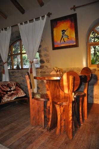 Valle Dorado Lodge في كوسكو: غرفة طعام مع طاولة وكراسي خشبية