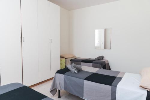 2 letti in una camera con pareti bianche di Cornigliano Apartment 3 a Genova