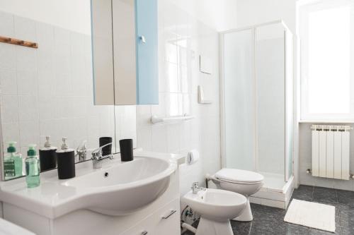 a white bathroom with a sink and a toilet at Cornigliano Apartment 3 in Genoa