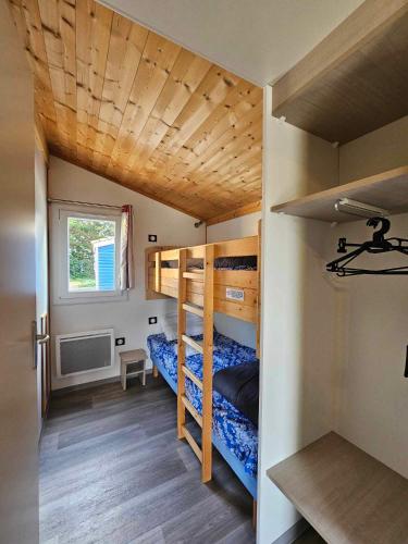 une chambre avec deux lits superposés et une fenêtre dans l'établissement Les Chalets de Moulière, à Vouneuil-sur-Vienne