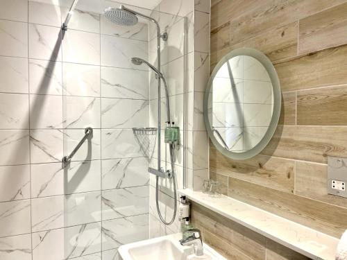 伯恩茅斯的住宿－Hotel Collingwood BW Signature Collection，带淋浴、盥洗盆和镜子的浴室