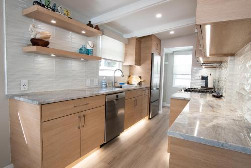 a kitchen with wooden cabinets and stainless steel appliances at La Jolla Windansea Luxury Apt in San Diego