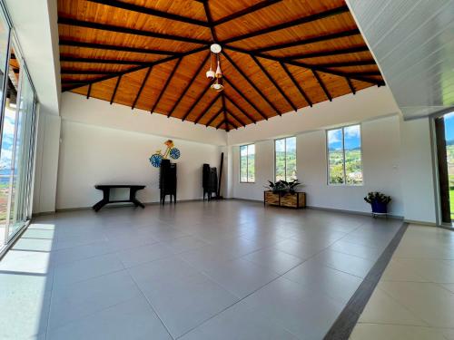 a large room with a wooden ceiling and a table at Hospedaje Lycaste in Tibasosa