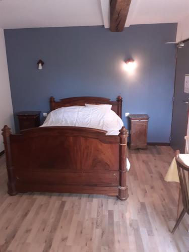 a bedroom with a wooden bed with a blue wall at Gîte 15 in Rogny