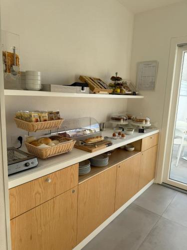 a kitchen with wooden cabinets and baskets of food at Chic & Charme Luxury Rooms in Olbia