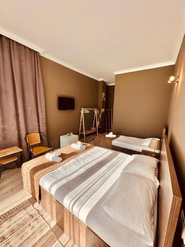 a bedroom with two beds and a television in it at WoodSea in Batumi