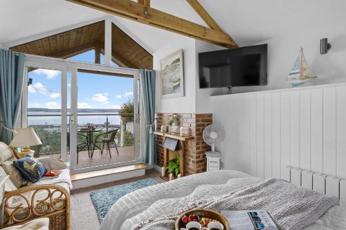 a bedroom with a bed and a view of the ocean at The Boathouse - Panoramic Sea View Retreat, near Town, Marina & Beach, with Parking in Torquay