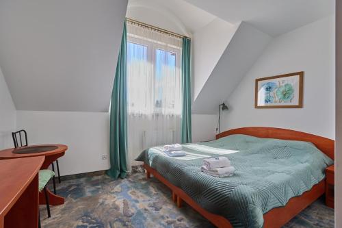 a bedroom with a bed and a table and a window at AVILA in Niechorze