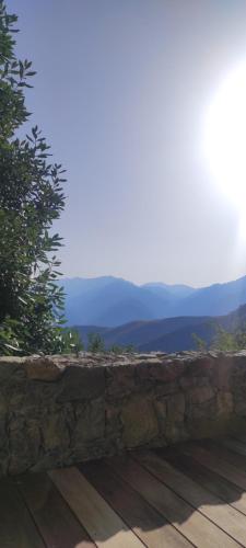 a stone wall with a view of the mountains at Parfumu Di Celu in Corte