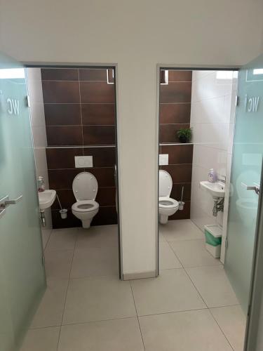 a bathroom with two toilets and two sinks at Apartmán Wellness Veselí in Veselí nad Moravou