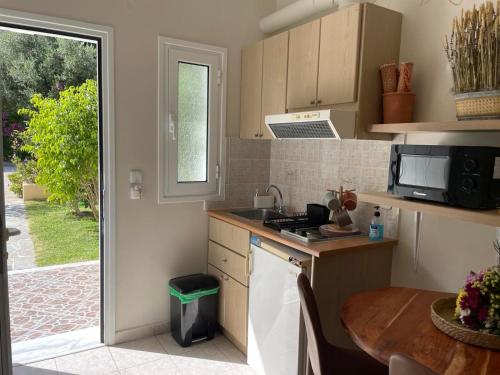 a kitchen with a sink and a table and a window at Stefanos Home in Katelios